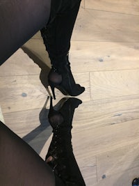 a woman's legs in black thigh high boots